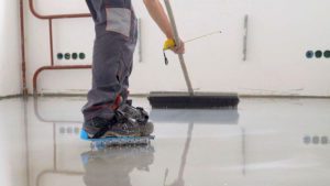 Worker applies epoxy floor coating
